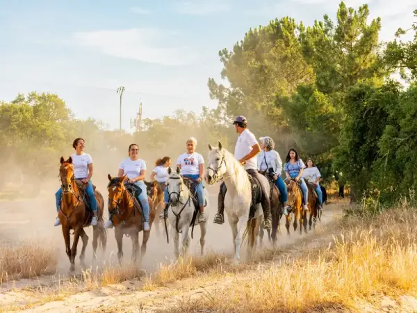 Aventura a caballo en grupo por la playa con degustación de tapas y obsequio de recuerdo.